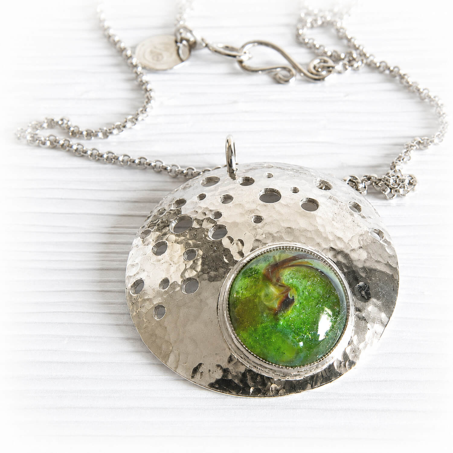 Green glass infused with the ashes of a lost loved one on a sterling silver memorial necklace