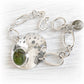 Polished sterling silver memorial bracelet featuring hand blown green glass with cremation ashes sealed within the glass
