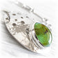 Green glass handcrafted with cremation ashes set onto a sterling silver remembrance keepsake