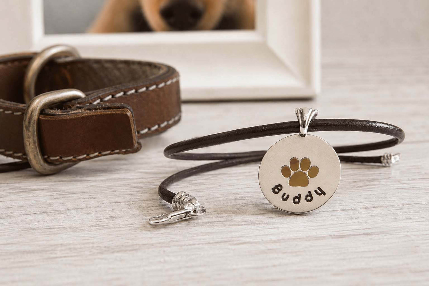 Sterling silver and leather pet memorial necklace with a paw print cut out and custom 'Buddy' engraving